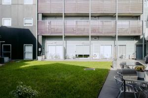 a building with a grassy yard in front of a building at Punthill Essendon in Melbourne