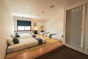 a row of beds in a room with a television at Adamo Akakura in Myoko +36 photos