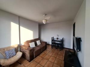 a living room with a couch and a table at Apartmento Moto GP in Goiânia