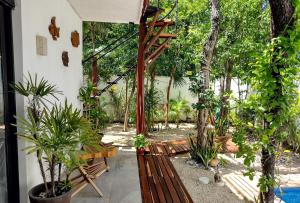 a garden with a wooden bench and plants at Villa Tucanes in Tulum
