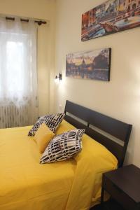 a bedroom with a yellow bed with pillows on it at Arcadia Domus in Rome