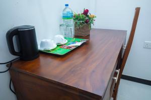 a wooden table with a bottle of water on top of it at River Shade Inn in Tissamaharama