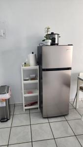 a kitchen with a stainless steel refrigerator and a shelf at JG Residences in San Juan