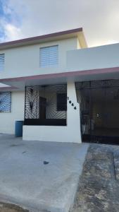 a white house with a gate and a garage at JG Residences in San Juan