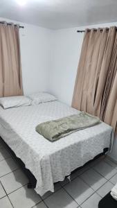 a bed with a blanket on it in a room with curtains at JG Residences in San Juan
