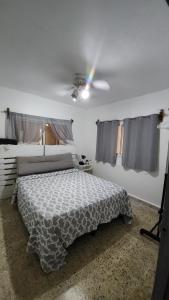 a bedroom with a bed and a ceiling fan at First Floor 2 Bed Apartment in La Ceiba