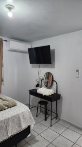 a bedroom with a table with a mirror and a tv at JG Residences in San Juan