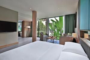 a bedroom with a large white bed and a living room at Hyatt Regency Phuket Resort in Kamala Beach