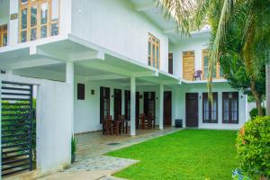a house with a green lawn in front of it at River Shade Inn in Tissamaharama