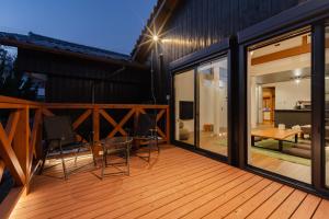 a deck with glass doors and chairs on a house at NODOKA Awajishima in Minamiawaji