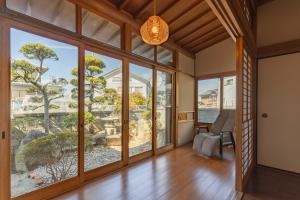 an empty living room with large windows and a chair at NODOKA Awajishima in Minamiawaji