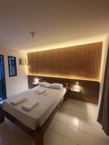 a bedroom with a large bed with two towels on it at Mar Azul Flats com Piscina, Cozinha mais estacionamento em Ponta N in Natal +72 photos