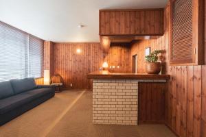 a living room with a couch and a kitchen at Adamo Akakura in Myoko