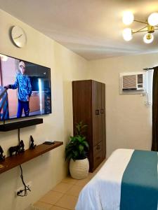 a hotel room with a tv and a bed at Norman Condominium Unit Rental in Dumaguete