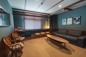 a living room with a couch and a table and chairs at Adamo Akakura in Myoko
