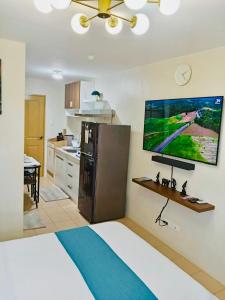 a kitchen with a bed and a television on the wall at Norman Condominium Unit Rental in Dumaguete