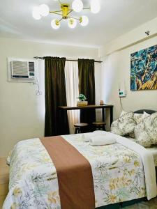 a bedroom with a bed and a table and a window at Norman Condominium Unit Rental in Dumaguete +70 photos
