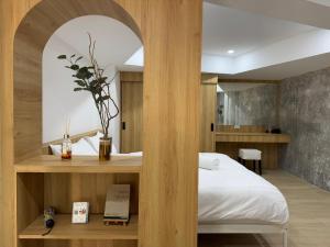 a bedroom with a white bed and a wooden wall at Baan Trok Bedroom Studio Maikhao in Mai Khao Beach