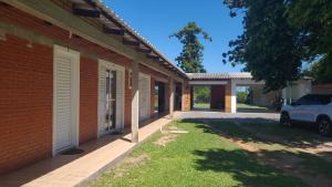 a building with a car parked next to a driveway at Pousada da Praça in Rosário do Sul