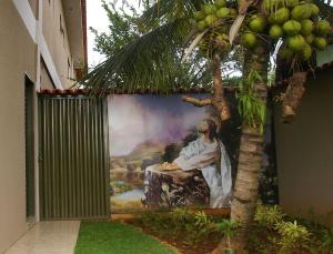 a painting of a man on a wall with a tree at Pousada Jesus De Nazare in Trindade