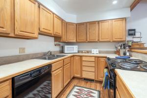 a kitchen with wooden cabinets and a stove top oven at Riverside Condos D02 condo in Telluride