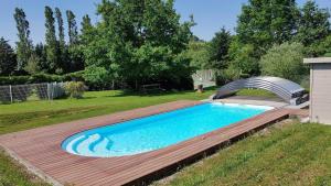 a swimming pool with a wooden deck and a metal bridge at Farguettou in Nailloux
