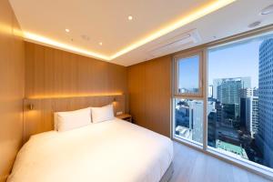 a bedroom with a white bed and a large window at SL Hotel Myeongdong in Seoul +33 photos