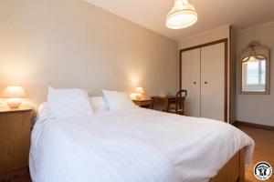 a bedroom with a large white bed with two lamps at Farguettou in Nailloux +30 photos