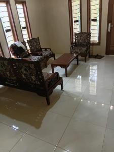 three chairs and a table in a living room at Musni Guest House in Tarusan