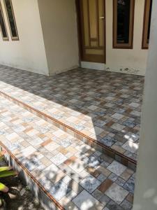 a room with a tiled floor in front of a door at Musni Guest House in Tarusan