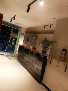 a room with a counter with a door and a plant at Hotel Laureles Park in Medellín