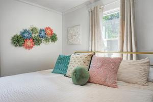 a bedroom with a bed with pillows and a window at Broad Ripple Getaway, Hot Tub, King Bed, Walk to Shops, Bike the Monon in Indianapolis