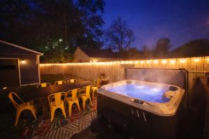 a hot tub in a backyard with a table and chairs at Broad Ripple Getaway, Hot Tub, King Bed, Walk to Shops, Bike the Monon in Indianapolis