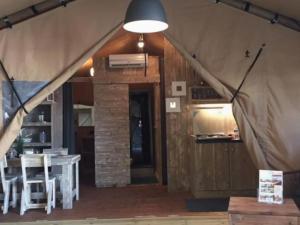 a tent with a dining room and a table at Tente avec terrasse - 2 pers. - API-1-52-2040 in Grayan-et-lʼHôpital