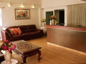 a living room with a couch and a coffee table at Hotel De Ratt in Phuket