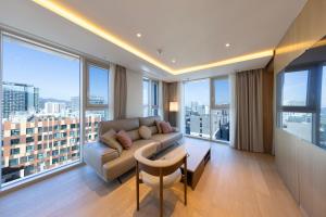 a living room with a couch and large windows at SL Hotel Myeongdong in Seoul
