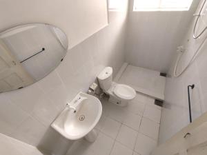 a white bathroom with a toilet and a mirror at W Hotel Mount Lavinia - Colombo in Colombo