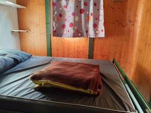 a blanket sitting on a bed in a room at Chalet avec terrasse - 6 pers. - API-1-52-2030 in La Tour-dʼAuvergne