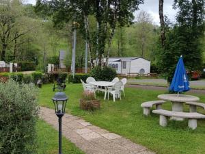 a patio with a table and chairs and a blue umbrella at Chalet avec terrasse - 6 pers. - API-1-52-2030 in La Tour-dʼAuvergne