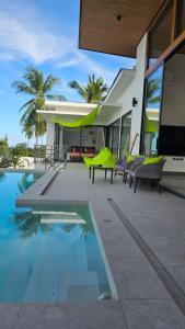 a house with a swimming pool next to a house at Villa Mona in Nathon Bay