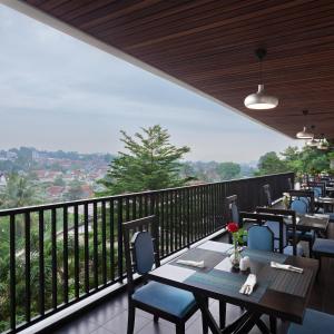 a restaurant with tables and chairs on a balcony at Grande Padjadjaran Hotel in Kamparganya
