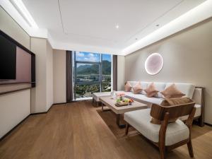 a living room with a couch and a table at Maison New Century Ninghai Railway Station in Ninghai