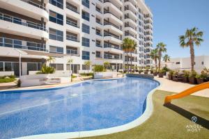 a swimming pool in front of a large apartment building at Gated Community Oceanview Condo Pool & Gym in La Paz