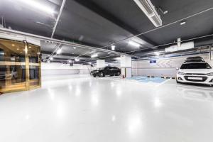 a garage with two cars parked in it at First Hotel in Guri