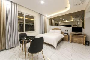 a hotel room with a bed and a table and chairs at Hotel Felice Dongchon Amusement park in Daegu