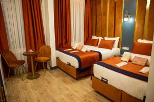 a hotel room with two beds and a table at crown taksim hotel in Istanbul