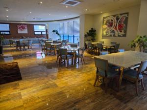 a restaurant with wooden floors and tables and chairs at First Hotel in Guri