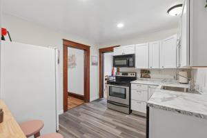 a kitchen with white cabinets and a stove top oven at Spacious 2BR Across from Como Lake - Bramble in Saint Paul