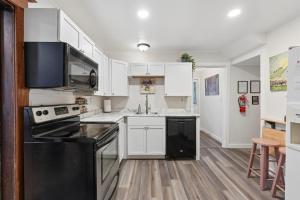 a kitchen with white cabinets and black appliances at Spacious 2BR Across from Como Lake - Bramble in Saint Paul