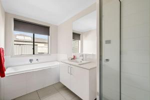 a white bathroom with a tub and a sink at Paradise Point Cowes in Cowes +15 photos